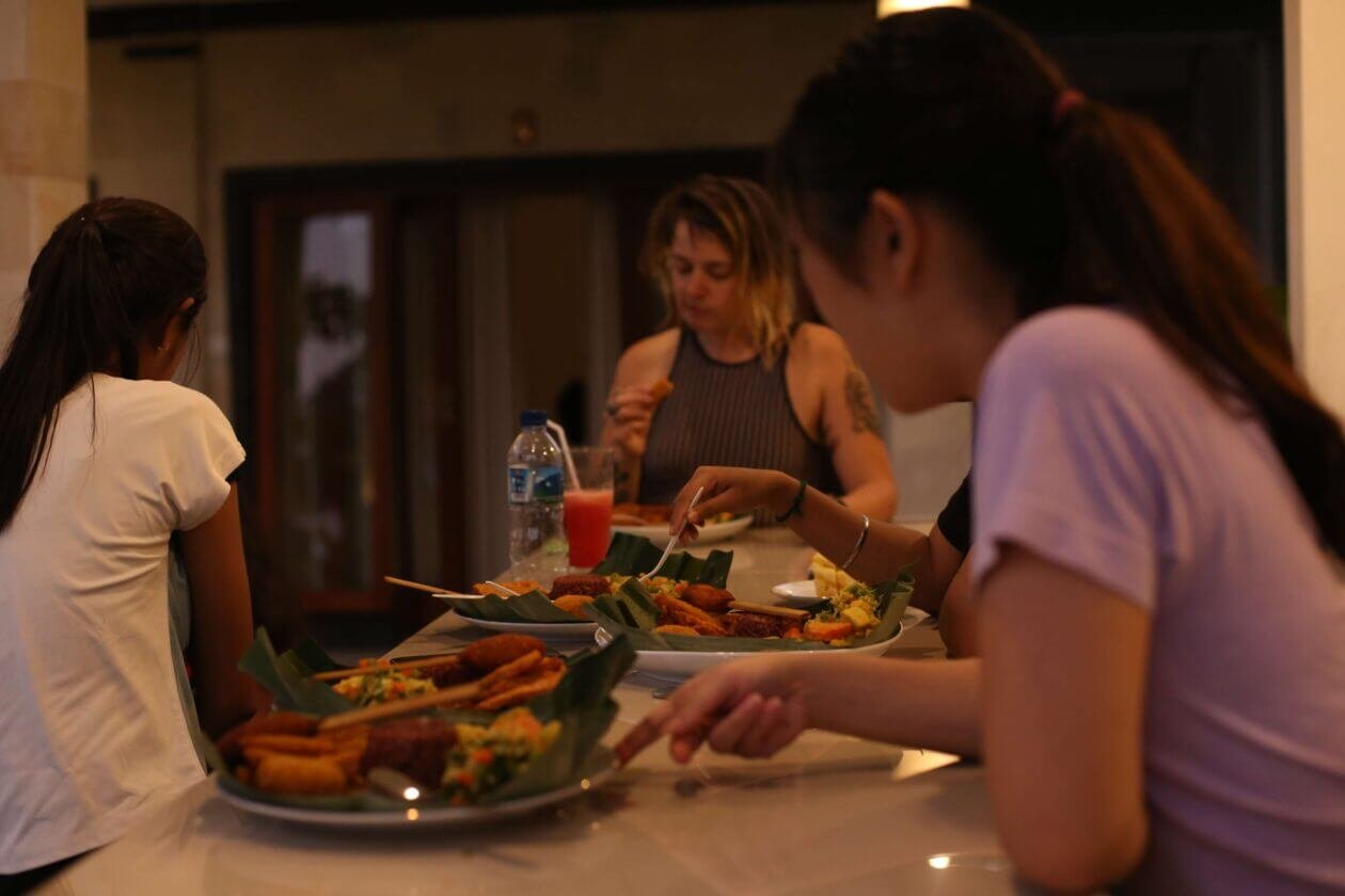 students of yoga teacher training eating food in banana leaves