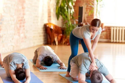 teacher teaching yoga to students